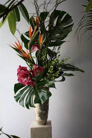 Tall Tropical Flower Arrangement Composition Of Monstera Leaves Birds Of Paradise Gre Tropical Flower Arrangements Modern Flower Arrangements Office Flowers