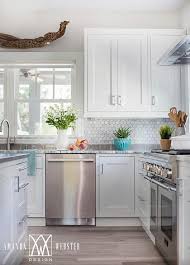 The same material is used for the countertops. White Cabinets With White Marble Hex Backsplash Cottage Kitchen