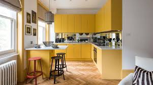 Traditional yellow kitchen cabinets and a contrasting wood island are topped with black and white countertops in this country style kitchen. 30 Beautiful Yellow Kitchen Ideas