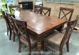 Sculptural metal bars clasping transparent acrylic legs Bainbridge 9 Piece Dining Set Costco Weekender