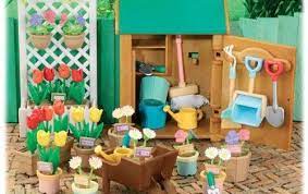 The set includes bench, 4x fence panel, tree, mailbox, 2x potted plant, watering can, 3x planter, 12x flower, 4x flower bunch, 4x flowers in basket, 3x gardening tool, 3x postcard, and newspaper. Gardening Shed Set Sylvanian Families Kids Playing Miniature Greenhouse