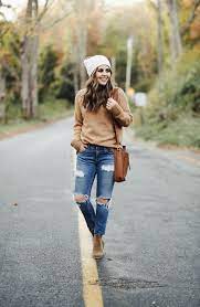 We see a camel coat layered over a white turtleneck sweater in oversized fit. Oversized Camel Colored Sweater With Jeans And Booties 3 Dress Cori Lynn