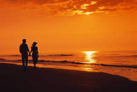 Back lit with lens flare. Two Night Sea Beach Silhouettes Sunset Couple Walking Beach Sunset Beach Silhouette Night Sea Sunset Silhouette