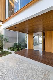 This Modern House Has A Pivoting Wood Front Door That Matches The Wood Used On The Upper Level Of Th Modern House Exterior Modern Family House Wood Front Doors