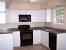 White Kitchen With Black Stainless Steel Appliances