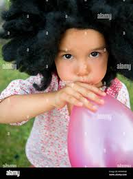 Ein junges Mädchen bläst einen Ballon im Central Park in New York City  Stockfotografie