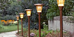 Extend the party into the night with these wood barrels made into planters with posts that hold string lights. Best Landscape Lighting To Illuminate Your Home And Yard At Night Better Homes Gardens