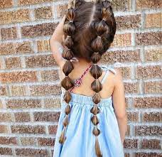 Many Rubber Hairbands Decorating The Two Long Pigtails Of A Small Child In A Pale Blue Summer Dre Toddler Hairstyles Girl Hair Styles Flower Girl Hairstyles