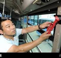 A Chinese bus worker equips a bus with glass breaking hammer ...