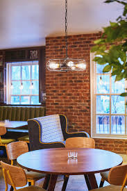 Vintage Industrial Light Fitting Over Contemporary And Cool Furniture Design Round Dining Tables With Funky Chairs Bar Restaurant Design By Tibbatts Abel S