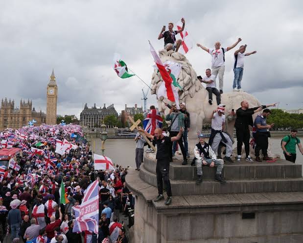 🚨 **Protest interrupts event on stage** A group of people were seen protesting and shouting from the stage during a public event, with a large crowd watching from below. The demonstration appeared