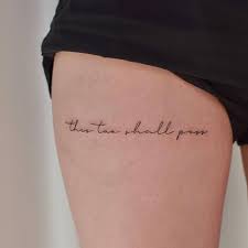 If you're getting dizzy trying to decipher the words, i've included them below: This Too Shall Pass Lettering Tattoo On The Thigh