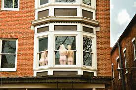 Four Young Nude Ladies Show Off Their Butts From A Window