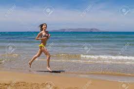Gorgeous Young Busty Long Haired Brunette Teenage Girl In Swimswear  Enjoying Jogging At The Beach In The Summer. Stock Photo, Picture and  Royalty Free Image. Image 43005220.