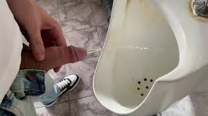 Guy orinando en el baño de la oficina pública
