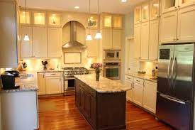 The dark finishes of the floors and the island's wood top add warmth to the creamy white kitchen. Cream Cabinets Dark Island Wood Floors Kitchen Pinterest Kitchen Design Eclectic Kitchen Kitchen Remodel