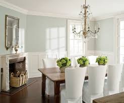 An arteriors analise chandelier hangs over wood top dining table surrounded by dark gray leather dining chair s and seating white slipcovered head chair s. Dining Room Paint Ideas With Chair Rail White Spray Paint Wood Picture Frame Dark Brown Va Brown Living Room Decor Chair Rail Paint Ideas Dark Wood Living Room