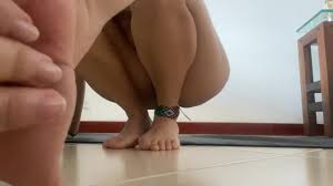 Latina haciendo yoga desnuda mientras sus vecinos la miran por la ventana