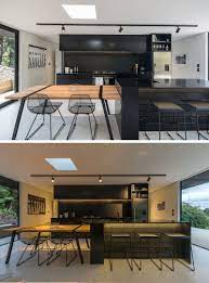 It's easy to swing and miss when you try to incorporate black kitchen design ideas. The Dark Wood Exterior Of This House Flows Through To The Interior Modern Black Kitchen Modern Kitchen Design Modern Kitchen
