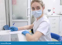 牙医助理或穿白色制服的女医生坐在牙科诊所的办公桌上库存照片. 图片包括有牙科医生, 手套, 患者- 267464462