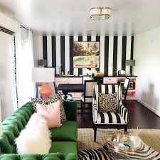 Cottage style solarium living room with beige and white striped furniture, one armchair being a living room space with two reddish brown chairs, one beige sofa and one beige armchair all around. Katie Kime S Colorful World Of Fashion And Decor The Glam Pad Striped Wallpaper Living Room Black And White Living Room Striped Room