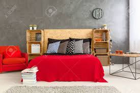 Manche von den schlafzimmer grau beispielen veranschaulichen, dass graue wände dramatik ausstrahlen. Modern Gestaltete Schlafzimmer Mit Roten Bett Und Sessel Auf Dem Hintergrund Graue Wand Holzboden Aus Holzkisten Und Kopfteil Aus Holz Auf Dem Bett Lizenzfreie Fotos Bilder Und Stock Fotografie Image 58998512