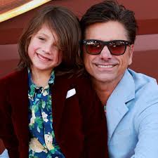John Stamos exclusively told E! News that he and wife Caitlin McHugh's  7-year-old son Billy has taken to name dropping his famous father, joking,  "He's using it with the girls.” bit.ly/3VM2HaW