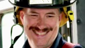 Law enforcement officers escort the body of Raymond Fire Captain