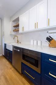 White Kitchen With Navy Base Cabinets Microwave Cabinet Next To Stainless Dishwasher And Wood Float White Galley Kitchens Galley Kitchen Design Galley Kitchen