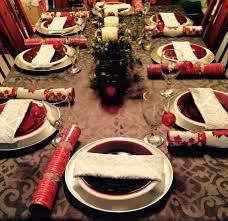 Rustic christmas place setting, plate, knife and fork wrapped with napkin on rustic wooden table, top view. Christmas Table Setting With Crackers Beside Plate Christmas Table Settings Table Settings Christmas Table