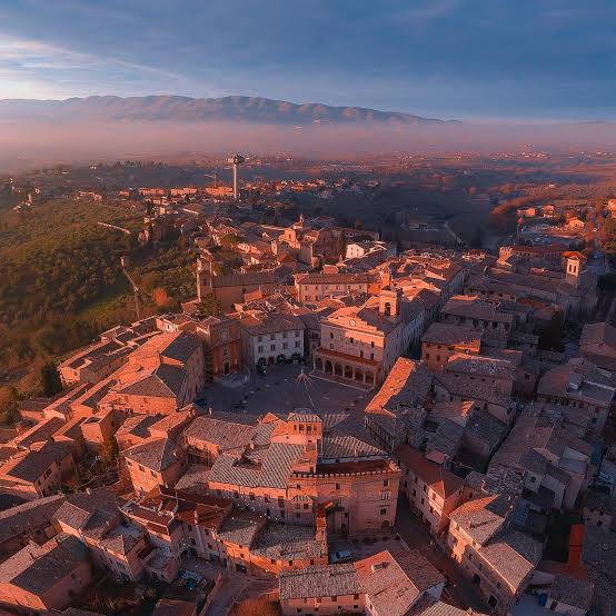 🍇✨ Montefalco, la “Ringhiera dell'Umbria”, vista dal cielo. Dall'alto,  questo borgo incantato si rivela in tutta la sua magia: un cerchio perfetto  di vie medievali, pietra dorata, tetti antichi e vign