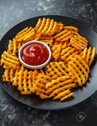 There are no losers here. Crispy Potato Waffles Fries With Ketchup In A Black Plate Stock Photo Picture And Royalty Free Image Image 103953347