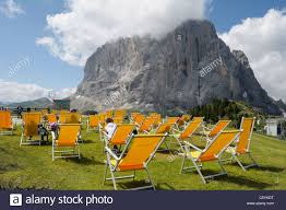 Der ciampinoi erhebt sich im süden von wolkenstein, mit kiefern bedeckt und geschützt vom langkofel, einem majestätischen. Liegestuhle Am Oberen Rand Der Ciampinoi Seilbahn In Der Nahe Von Selva Val Gardena Dolomiten Italien Mit Blick Auf Den Sasso Lungo Stockfotografie Alamy
