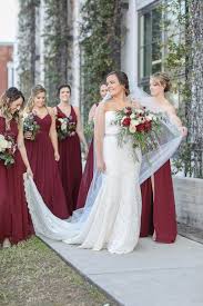 While many brides globally may also opt for a white wedding gown for a modern touch, traditional ceremonies, like tea ceremonies and. Bride In Strapless Lace And Fitted Wedding Dress With Rhinestone Belt And Cathedral Length Veil And Bridesmaids In Long Burgundy Wine Red Dresses Holding Garden Style Red Ivory And Greenery Floral Bouquets
