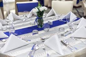 On the left side of the plate should be your forks. Reception Dinner Celebration Party Table Setup With Dinnerware Napkin Spoon Fork And Glasses Decoration With Blue Sash Cloth Stripe Stock Photo 63fffb84 93ae 4925 9056 C7c82a9ffb8e