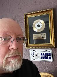 Who is the musician in the photo with the song excerpt about a boring job  and fantasies?