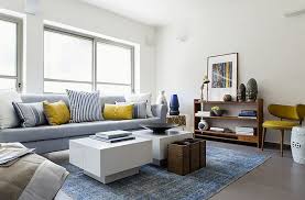 Grey and blue family room features walls painted gray, benjamin moore shoreline, lined with a grey tufted sofa with silver nailhead trim lined with gray chevron pillows facing a gray scroll bench with white piping across from a cream mirrored tray coffee table atop a cream cowhide rug. Pin On Zolte Detale We Wnetrzach Dekoracje Sklep Decoart24 Pl
