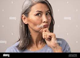 Belle femme mature suce les lèvres en touchant son menton Photo Stock -  Alamy