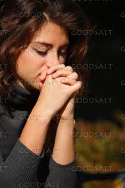 IDAHO. Boise. Young woman praying (close-up). MR