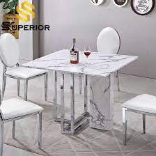 This circular table is rather contemporary in its design and comes complete with a faux marble top. China Elegant White Granite And Marble Top Dining Table Stainless Steel China Marble Dining Table Modern Table