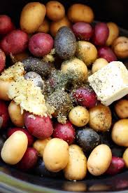 Crock Pot Filled With Red Purple And White Potatoes With Herbed Seasoning Garlic And Butter Garlic Roasted Potatoes Crock Pot Potatoes Purple Potato Recipes