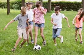 Unos juegan a pasar debajo de la cuerda, otra juega al truque y otros juegan a apilar cubos. Ninas Y Ninos Jugando Al Futbol Foto Premium