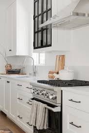 White kitchen cabinets with black hardware morespoons where to place. Black And White Glass Panel Kitchen Cabinets In A Transitional Kitchen Above A Cooktop Design White Marble Kitchen Transitional Kitchen Framed Kitchen Cabinets