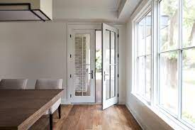 Enlarged grilles on the doors mimic the look of windows. Wood French Doors With Custom Grille Pattern Pella