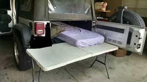 Sleep In 4 Door Jeep Wrangler By Placing A Table At The End Of The Jeep And Extended The Mattress Outside Jeep Camping 4 Door Jeep Wrangler Jeep
