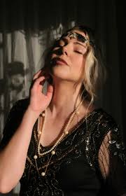 A woman in a black dress is holding a necklace photo