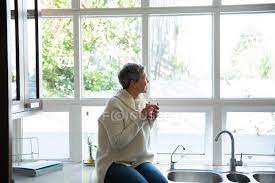 If you mean that they are on the table/counter, and sit on the edge, they do that because they are both predators and prey, and this give them a god's eye view of potential food and dangerous predators. Side View Of A Mature Caucasian Woman With Short Grey Hair Sitting On The Counter In
