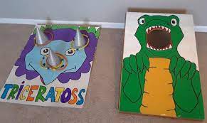 Dinosaur Birthday Games For A 5 Year Old Triceratoss And T Rex Cornhole Dinosaur Themed Birthday Party Dinosaur Party Games Dinosaur Theme Party