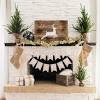 Christmas decorations hanging over a fireplace, xmas lettering leaning against a mirror christmas decorations hanging over a fireplace. 1
