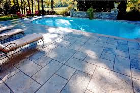 This pool is bordered with black river rock and concrete slabs with limestone copping. Installing Anti Slip Decorative Concrete Pool Decks Sundek